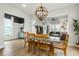 Open-concept dining room with decorative chandelier, an open view to the living room, and a black accent wall at 115 Winding Branch Dr, Summerville, SC 29486