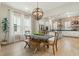 Elegant dining area with a unique light fixture, stylish wallpaper, and views of the open-concept kitchen at 115 Winding Branch Dr, Summerville, SC 29486