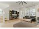 Open living room features a wooden TV stand with shelves, comfortable seating, and large windows for natural light at 115 Winding Branch Dr, Summerville, SC 29486