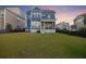 A two-story blue home featuring a large backyard and a screened porch, perfect for outdoor gatherings at dusk at 1251 Weather Helm Dr, Mount Pleasant, SC 29466