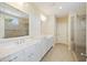 A bright bathroom features double sinks with marble countertops, a glass shower, and tile flooring at 1251 Weather Helm Dr, Mount Pleasant, SC 29466