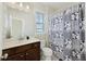 Bright bathroom features a dark wood vanity, neutral countertop, decorative mirror, and patterned shower curtain at 1251 Weather Helm Dr, Mount Pleasant, SC 29466