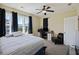 Well-lit bedroom with large windows, a ceiling fan, and a comfortable bed near a desk at 1251 Weather Helm Dr, Mount Pleasant, SC 29466