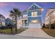 Charming two-story blue home with a white garage and inviting front porch at dusk at 1251 Weather Helm Dr, Mount Pleasant, SC 29466