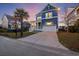 Blue two-story home with inviting front porch and two-car garage, bathed in the warm glow of twilight at 1251 Weather Helm Dr, Mount Pleasant, SC 29466