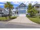 Charming blue home with a front porch, palm tree, and a spacious driveway leading to a two-car garage at 1251 Weather Helm Dr, Mount Pleasant, SC 29466