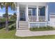 Charming front porch with white columns, blue siding, and well-manicured landscaping at 1251 Weather Helm Dr, Mount Pleasant, SC 29466