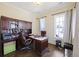 A traditional-style office is furnished with a wooden desk, cabinets, and comfortable seating and neutral walls at 1251 Weather Helm Dr, Mount Pleasant, SC 29466
