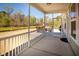 Covered patio with screen and railing overlooks the manicured lawn and wooded views at 126 Citrea Dr, Summerville, SC 29483