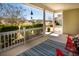 Inviting porch features bright sunlight, red rocking chair, and green landscaping along the white railing at 126 Citrea Dr, Summerville, SC 29483