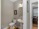 Well-lit powder room featuring a pedestal sink, toilet, and decorative mirror at 126 Citrea Dr, Summerville, SC 29483