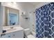 Well-lit bathroom featuring a shower-tub combo, a white vanity with a sink, and elegant blue accents at 131 Brant Dr, Summerville, SC 29483