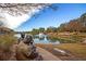 Scenic community lake view with a fountain, bronze statues, landscaping, and blue skies at 131 Brant Dr, Summerville, SC 29483