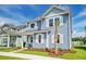 Charming two-story blue home with white trim, shutters, a well-manicured lawn, and a vibrant palm tree at 131 Brant Dr, Summerville, SC 29483