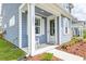 Charming porch with a small white rocking chair and a neatly landscaped flower bed at 131 Brant Dr, Summerville, SC 29483