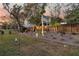 Landscaped backyard with a wooden fence, mature trees, and accent lighting for evening enjoyment at 134 Country Oaks Ln, Wando, SC 29492