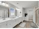 Spacious bathroom with double sinks, white cabinets, and a framed window at 134 Country Oaks Ln, Wando, SC 29492