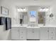 Bright bathroom with double sinks, white cabinets, and modern light fixtures at 134 Country Oaks Ln, Wando, SC 29492
