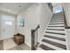 Inviting entryway featuring wood-look floors, a staircase, and a charming wooden bench at 134 Country Oaks Ln, Wando, SC 29492