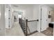 Upstairs hallway with neutral carpet, decorative railing, and access to rooms at 134 Country Oaks Ln, Wando, SC 29492