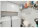 Well-lit laundry room featuring modern appliances, white cabinets and extra storage space at 134 Country Oaks Ln, Wando, SC 29492