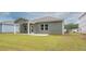 The backyard features a green lawn and view of the home's exterior siding and back porch at 135 Royal Cainhoy Way, Huger, SC 29450