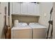 Practical laundry room equipped with a washer, dryer, and overhead storage cabinets at 1413 Basildon Rd, Mount Pleasant, SC 29466