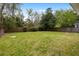 Lush backyard features a large green lawn bordered by a wooden fence and mature trees, providing privacy at 1423 Bexley St, North Charleston, SC 29405