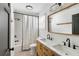 Bright bathroom boasts a dual sink vanity, marble countertop, modern fixtures, and shower with black and white curtain at 1423 Bexley St, North Charleston, SC 29405