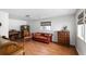 Cozy living room offers hardwood floors, a classic red leather sofa, and an antique wooden cabinet at 1423 Bexley St, North Charleston, SC 29405