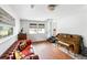 Inviting living room showcases hardwood floors, a vintage piano, and a comfortable red leather sofa near bright windows at 1423 Bexley St, North Charleston, SC 29405