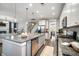 Open kitchen with granite counters and stainless appliances that opens to living room and staircase at 155 Village Ponds Dr, Summerville, SC 29483
