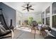 Cozy screened porch with comfortable seating, ceiling fan, and view of the lush backyard at 155 Village Ponds Dr, Summerville, SC 29483
