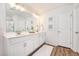 Bright bathroom featuring double sinks, white cabinets, framed mirror, and wood-look flooring at 162 Winding River Dr, Johns Island, SC 29455