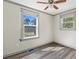 This light-filled bedroom offers updated flooring, ceiling fan, and natural light from two windows at 1634 Sumner Ave, North Charleston, SC 29406
