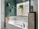 Bright bathroom features a soaking tub, decorative tile backsplash, and stylish shelves with plants at 176 Daniels Creek Cir, Goose Creek, SC 29445