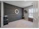 Bedroom featuring a dark accent wood paneled wall with a round mirror and carpeted floors at 176 Daniels Creek Cir, Goose Creek, SC 29445
