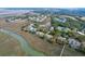 Expansive aerial view highlighting marsh-front home community with tennis courts and a waterway at 1806 Long Bend Dr, Seabrook Island, SC 29455
