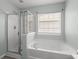 Bathroom showcasing a shower and soaking tub for ultimate relaxation and natural light at 206 Woodbrook Way, Moncks Corner, SC 29461