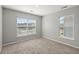 Well-lit bedroom with neutral-toned carpet, walls, and two bright windows at 206 Woodbrook Way, Moncks Corner, SC 29461