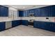 Well-lit kitchen features blue cabinets, marble countertops, and stainless steel appliances at 206 Woodbrook Way, Moncks Corner, SC 29461