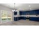Bright kitchen with blue cabinetry, stainless steel appliances, and sliding glass doors to the backyard at 206 Woodbrook Way, Moncks Corner, SC 29461