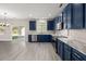 Open kitchen with blue cabinets, stainless steel appliances, and marble countertops at 206 Woodbrook Way, Moncks Corner, SC 29461