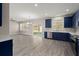 Bright open concept kitchen with blue cabinets, stainless steel appliances, and access to the backyard at 206 Woodbrook Way, Moncks Corner, SC 29461