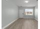 Bright living room featuring new light-gray flooring, a window, and a freshly painted white door at 206 Woodbrook Way, Moncks Corner, SC 29461