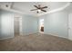 Large main bedroom showcasing carpeted floors, soft paint, a ceiling fan, and access to a closet and bathroom at 206 Woodbrook Way, Moncks Corner, SC 29461