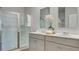 Modern bathroom boasts a double vanity with quartz countertops, framed mirrors, and a glass-enclosed shower at 2279 Macallan Blvd, Ravenel, SC 29470