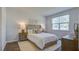 Bright bedroom features wood floors, a plush bed with white cover, and matching nightstands with stylish lamps at 2279 Macallan Blvd, Ravenel, SC 29470