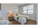 Bedroom features a large window, and natural light, with a comfortable bed and decorative bedside table at 2279 Macallan Blvd, Ravenel, SC 29470