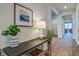 Inviting foyer features decorative table with lamps, plants and artwork on wall, with view into other rooms at 2279 Macallan Blvd, Ravenel, SC 29470